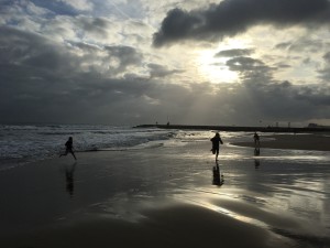 Barnen springer på stranden